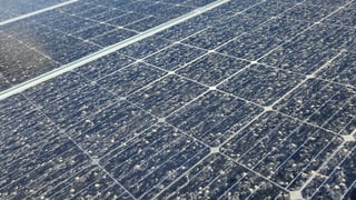 Dirty solar panel being cleaned