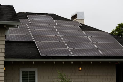 Solar panels on resort hotel roof with overcast sky